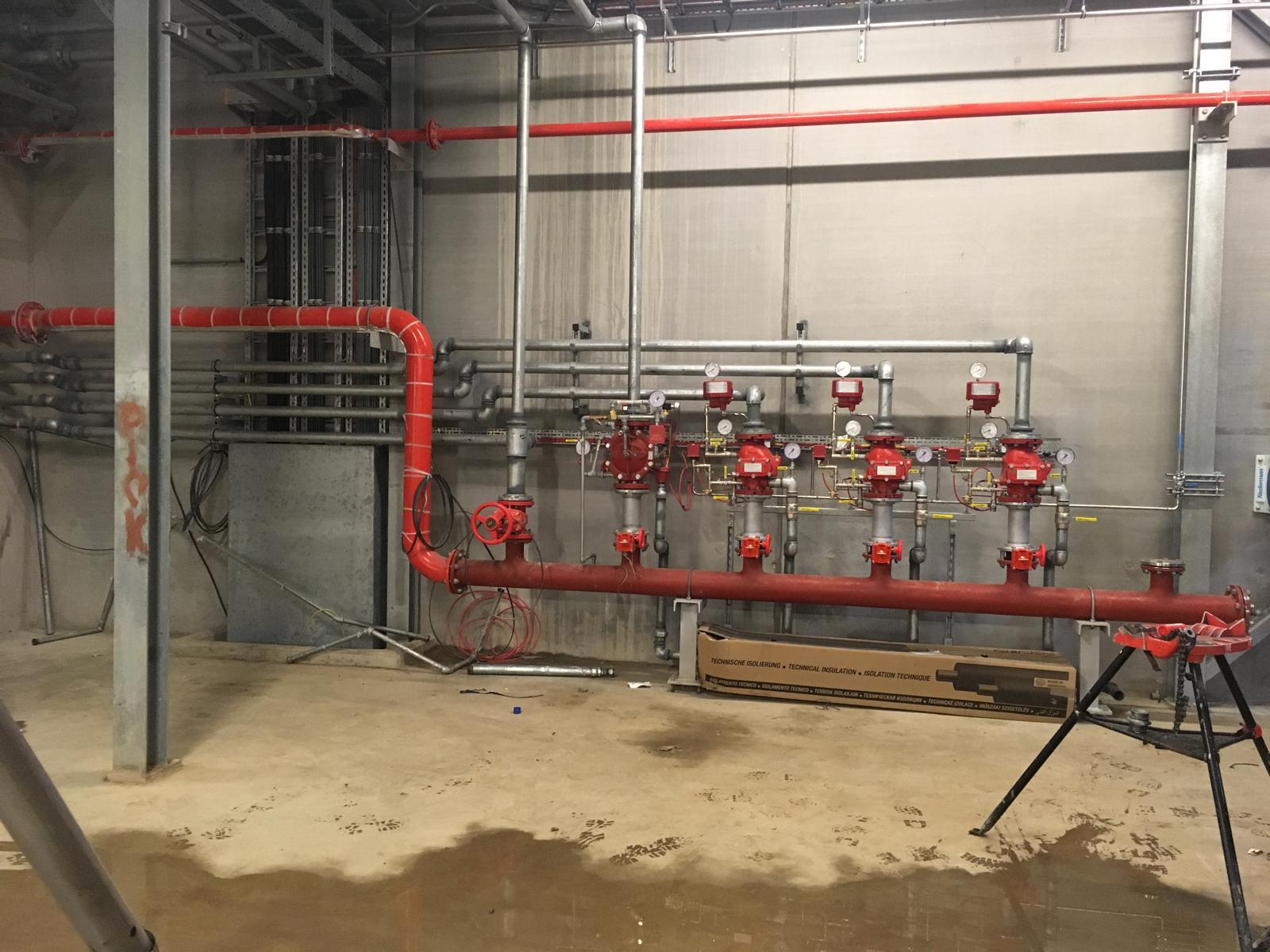 Red fire main with deluge valve stations and pressure gauges at Discovery Park, Kent